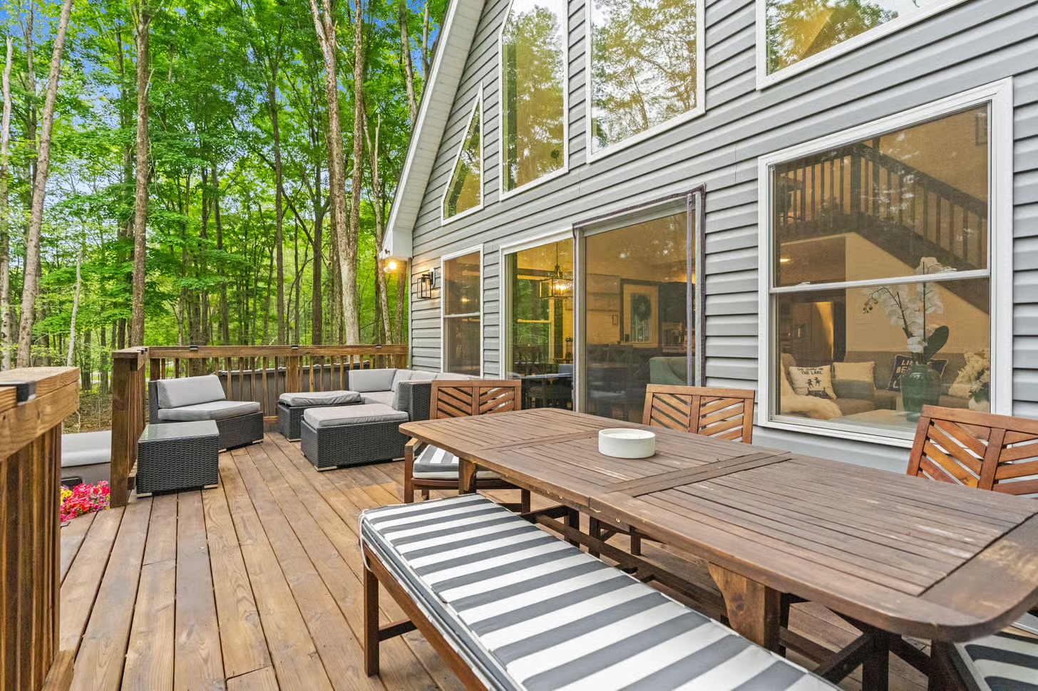 Wraparound deck with outdoor dining beneath the trees