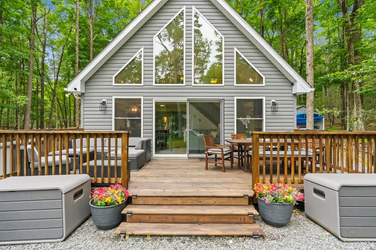 A-frame chalet façade with soaring triangular windows and wraparound deck